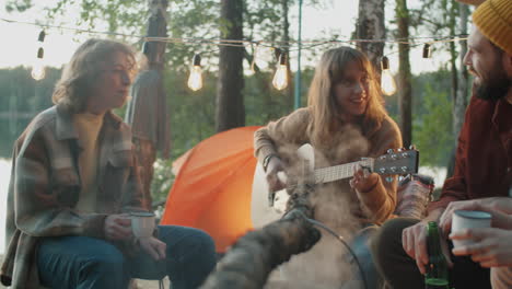 Girls-Playing-Guitar-and-Singing-by-Campfire